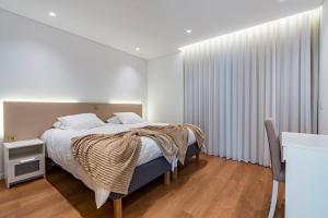 une chambre avec un lit avec des draps blancs et une fenêtre dans l'établissement Villa Bisa II, jacuzzi and sea view, à Arco da Calheta