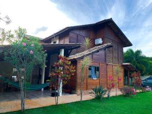 a wooden house with a hammock in front of it at Casa - Guarapari in Guarapari
