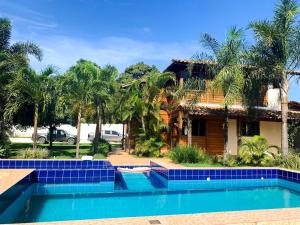 a house with a swimming pool in front of a house at Casa - Guarapari in Guarapari