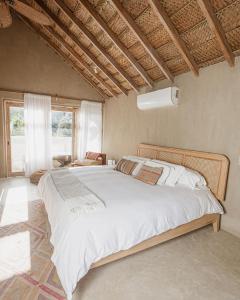 a bedroom with a large bed with white sheets at La Fragata in Vichayito