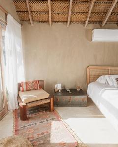 a bedroom with a bed and a chair and a table at La Fragata in Vichayito