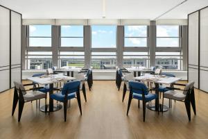 een eetkamer met tafels, stoelen en ramen bij Fairfield by Marriott Yancheng Dafeng in Yancheng