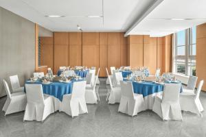 een conferentiezaal met tafels en witte stoelen en een tafeltennistafel bij Fairfield by Marriott Yancheng Dafeng in Yancheng