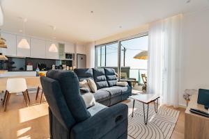 un salon avec un canapé bleu et une cuisine dans l'établissement Villa Bisa II, jacuzzi and sea view, à Arco da Calheta