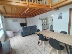 a living room with a large wooden table and chairs at Appartement 3 Chambres Bollezeele in Bollezeele