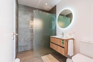 une salle de bain avec un lavabo et un miroir dans l'établissement Villa Bisa II, jacuzzi and sea view, à Arco da Calheta 67 autres photos