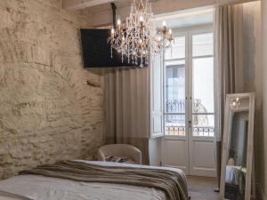 a bedroom with a bed and a chandelier at Cielo Cagliari For2 Design - Comfort Solo Adulti in Cagliari