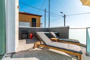 d'une terrasse avec un canapé sur un balcon. dans l'établissement Villa Bisa II, jacuzzi and sea view, à Arco da Calheta