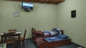 a room with a bed and a table and a television at Departamento Monoambiente-Selva Stay Iguazu in Puerto Iguazú