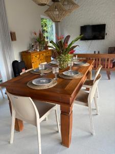 een houten tafel met borden en glazen erop bij Villa Tropicana in Saubara