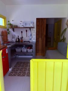 una cucina con tavolo giallo in una camera di Villa Tropicana a Saubara