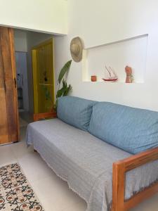 een slaapkamer met een bed met een blauwe deken bij Villa Tropicana in Saubara