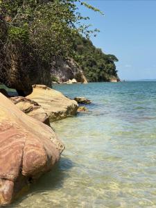 een strand met rotsen in het water en bomen bij Villa Tropicana in Saubara