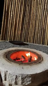 een stenen vuurkorf met een vuur erin bij Villa Tropicana in Saubara +5 foto's