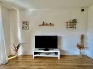 a living room with a flat screen tv on a white table at Wohnglück Seifferer in Ravensburg