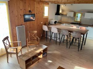cocina con mesa, sillas y barra en Residence des oiseaux, en Lesponne