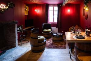 a living room with red walls and a table and chairs at Chai numéro 12, une immersion au coeur du vin in Bergerac