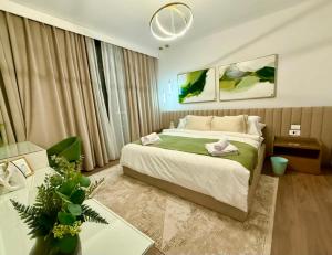 a bedroom with a large bed and a table and a couch at Luxury Apartments in Cairo Festival City in Cairo