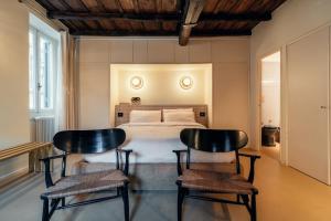 una camera con un letto e due sedie nere di House of Allora a Roma