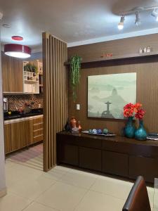 eine Küche mit einer Theke mit Blumenvasen darauf in der Unterkunft Casa top pertinho da praia com piscina e área gourmet in Arraial do Cabo