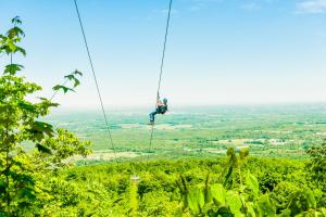 a man on a zip line in the jungle at Chateau Ridge in Blue Mountains +3 photos