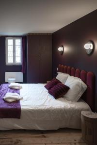 a bedroom with a large white bed with a red headboard at Chai numéro 12, une immersion au coeur du vin in Bergerac