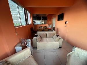 a living room with two white chairs and a table at Lindo Nascer do Sol in Recife +19 photos