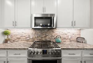 eine Küche mit Herd und Mikrowelle in der Unterkunft Chic 4BR Retreat Near Downtown in Oklahoma City + 27 Fotos