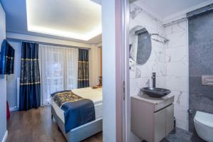 a bedroom with a bed and a bathroom with a sink at Hotel Martini in Istanbul