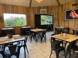 a restaurant with wooden walls and tables and chairs at Huillín Lodge in Huillinco