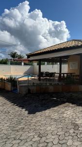 a pavilion with tables and chairs in a pavillion at Casa Rocha in Porto Seguro