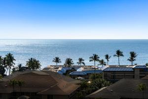 カイルア・コナにあるKona Mansions D231のヤシの木や家々が生い茂る海の景色を望めます。