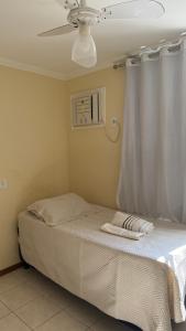 a bed in a bedroom with a ceiling fan at Casa Rocha in Porto Seguro +7 photos