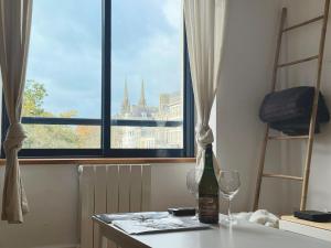 a bottle of wine sitting on a table with two glasses at Quimper: T3 avec vue cathédrale proche gare in Quimper +6 photos