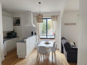 a kitchen and living room with a white table and chairs at Quimper: T3 avec vue cathédrale proche gare in Quimper