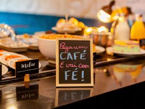 a table with a sign that says aecake cafe and wax germ fed at Golden Tower Express Braz Olaia by Fênix Hotéis in Ribeirão Preto +3 photos