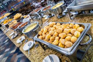 a buffet of food on a counter in a restaurant at Hotel Vilage Inn All Inclusive Poços de Caldas By Nacional Inn in Poços de Caldas