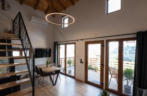 a dining room with a table and a staircase at Korifes Meteora lithari 01 in Kalabaka