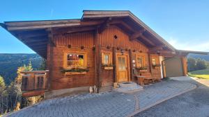 a log cabin with a porch and a patio at Kleinbergsonne in Filzmoos