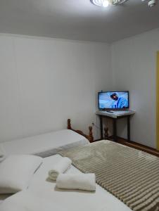 a bedroom with a bed and a laptop on a table at Hotel Linassi in Cruz Alta