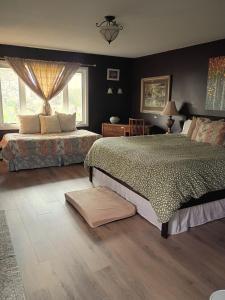 a bedroom with two beds and two windows at Biking, Hiking, Getaways & Relaxation Retreats - Visit the VT Chocolate Room - Large & Cozy, Homey, Jacuzzi Tub, Scenic Walks in Colchester
