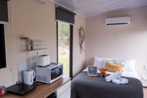 Doyles CreekBundaleer Tiny House 2 by Tiny Away的一间带床和电视的小卧室