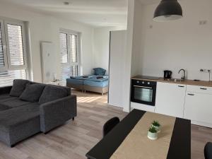 a kitchen and a living room with a couch and a table at Ferienwohnung mit Balkon in Steinhagen in Steinhagen