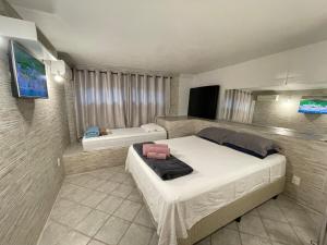 a bedroom with two beds and a television in it at Casa Arborizada - Bairro João Paulo Norte da ilha in Florianópolis