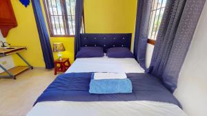 a bedroom with a bed with a blue headboard at Caribbean Sun Apart Hotel in Punta Cana +12 photos