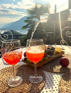 two wine glasses on a table with a tray of food at Villa Silvana in Perledo