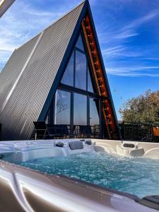 a large hot tub with a triangular building at A frame pool house in Ledinci