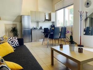 a living room and kitchen with a couch and a table at Nefele - Athens Airport Home in Artemida +2 photos
