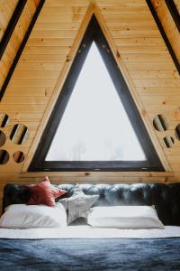 a couch in a room with a large window at A frame pool house in Ledinci