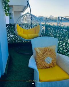 a chair with a pillow and a swing on a balcony at Coastal Gem 3BR, Pool, 5 Min Walk to Beach - Nyali in Nyali